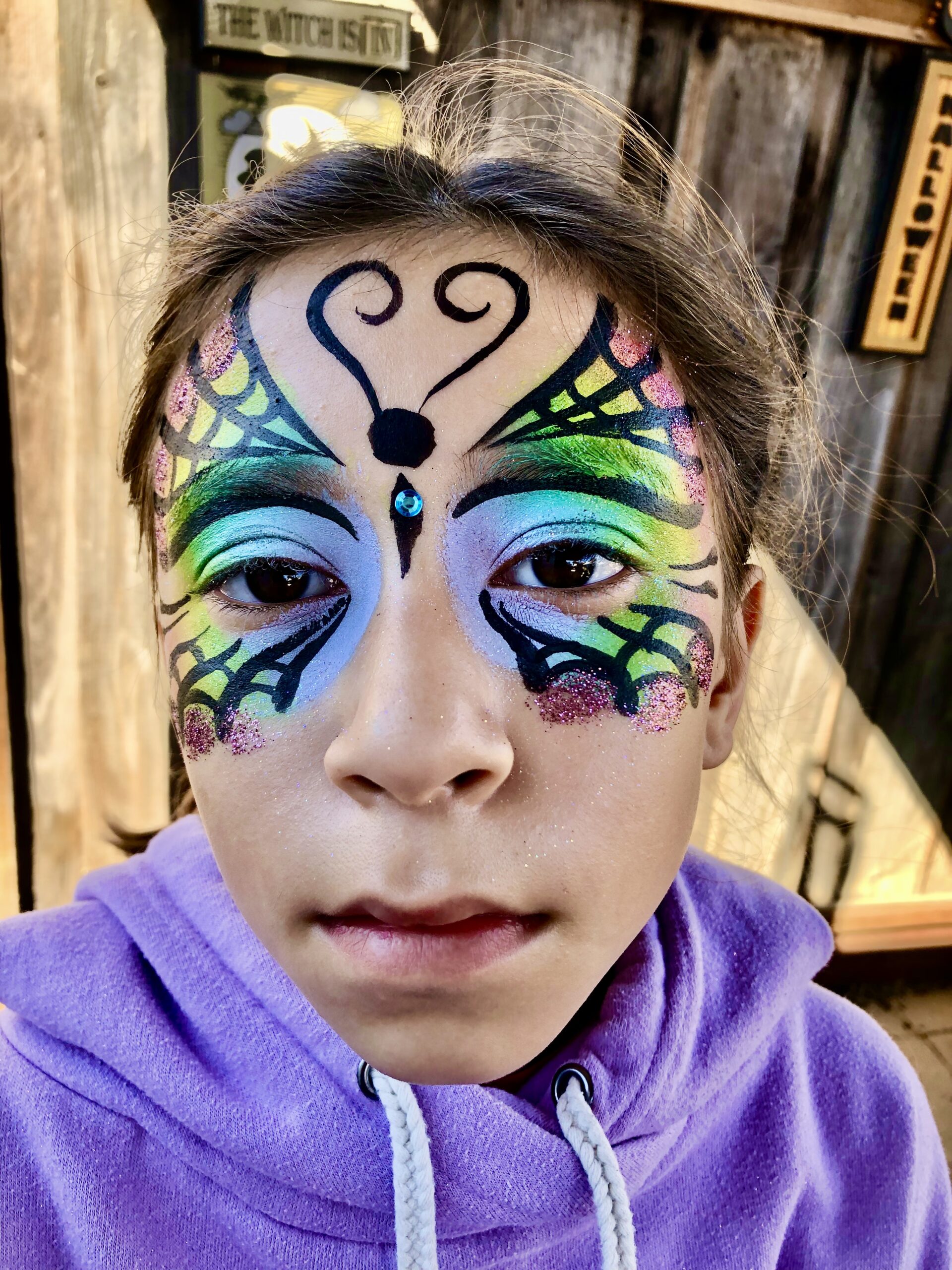 A webbed rainbow butterfly painted on a 13 year old girl